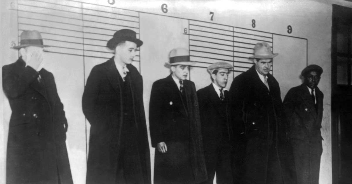 men wearing black coats and hat in black and white photo